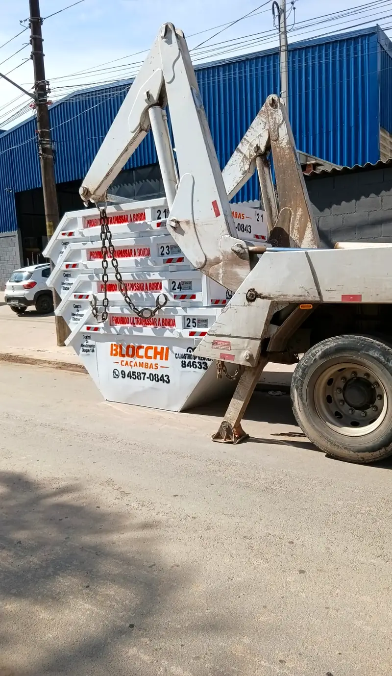 Caminhão poliguindaste da Blocchi Caçambas transportando caçamba de entulho