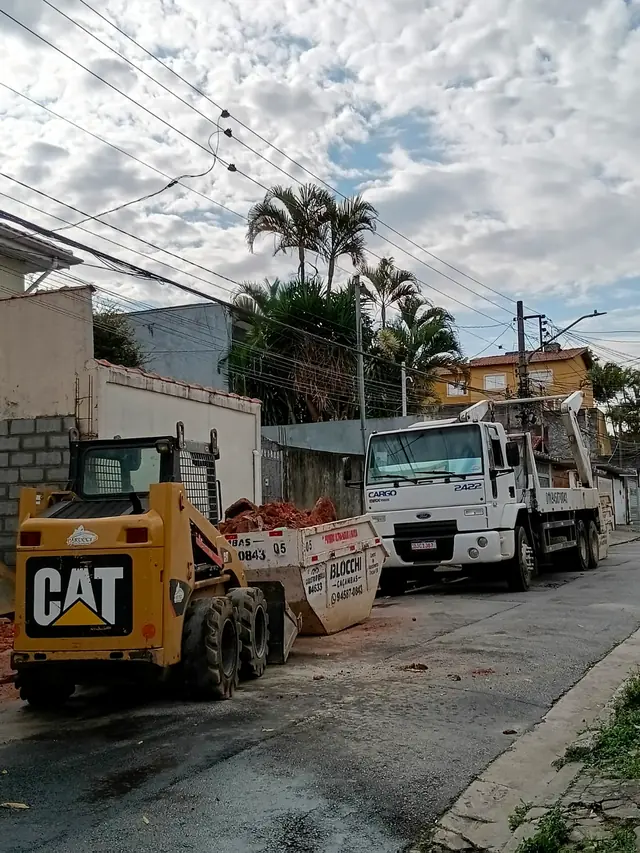 Minicarregadeira e caminhão da Blocchi Caçambas atendendo uma obra